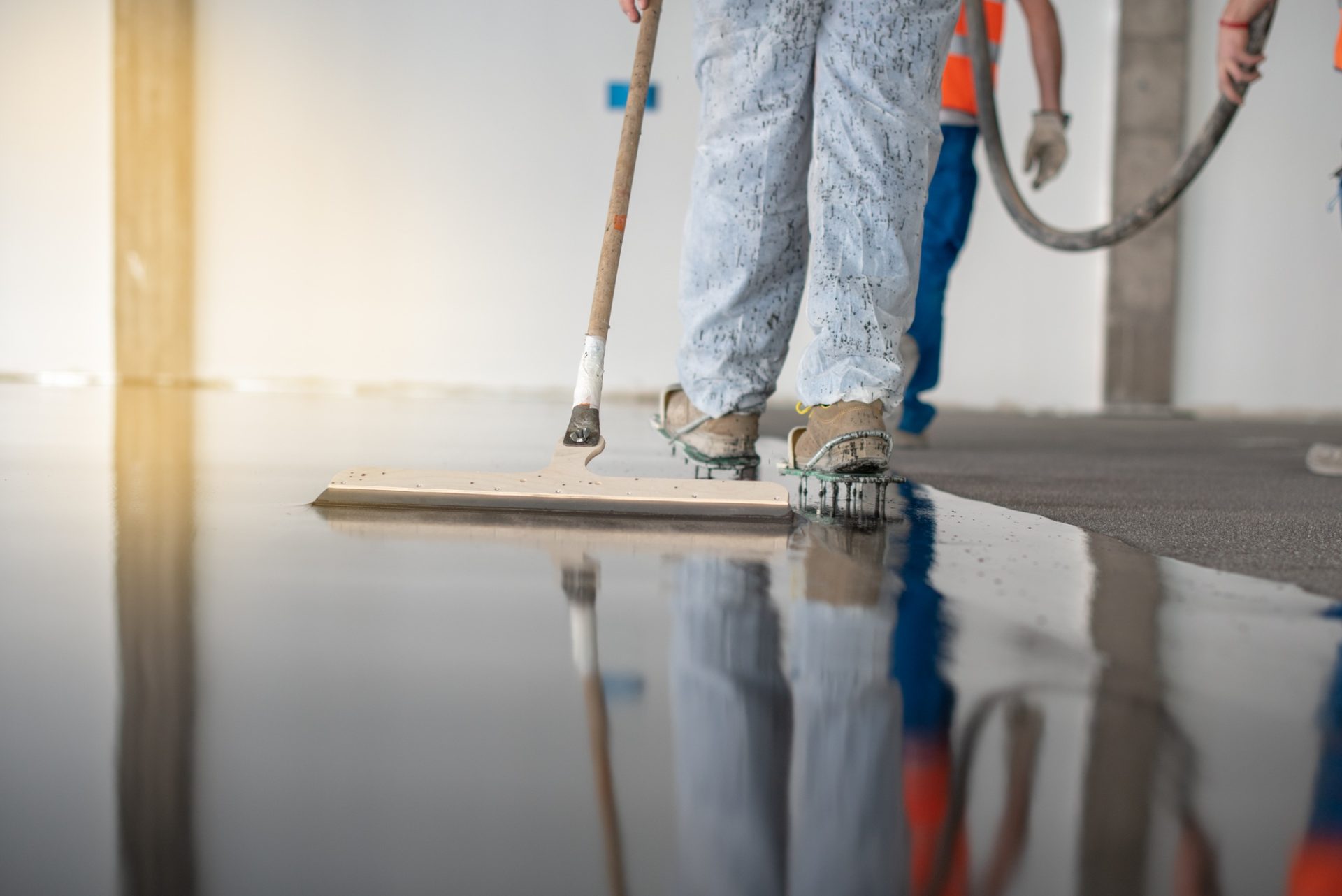worker working on the floor of an industrial building with special shoes to avoid damaging the floor